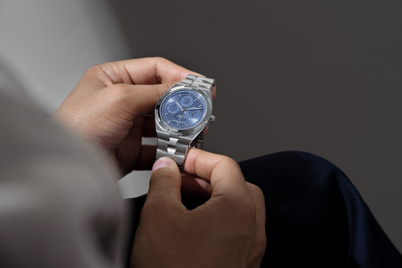 Vacheron Constantin Overseas Perpetual Calendar Ultra-Thin beyaz altın bileziğiyle elde tutulurken