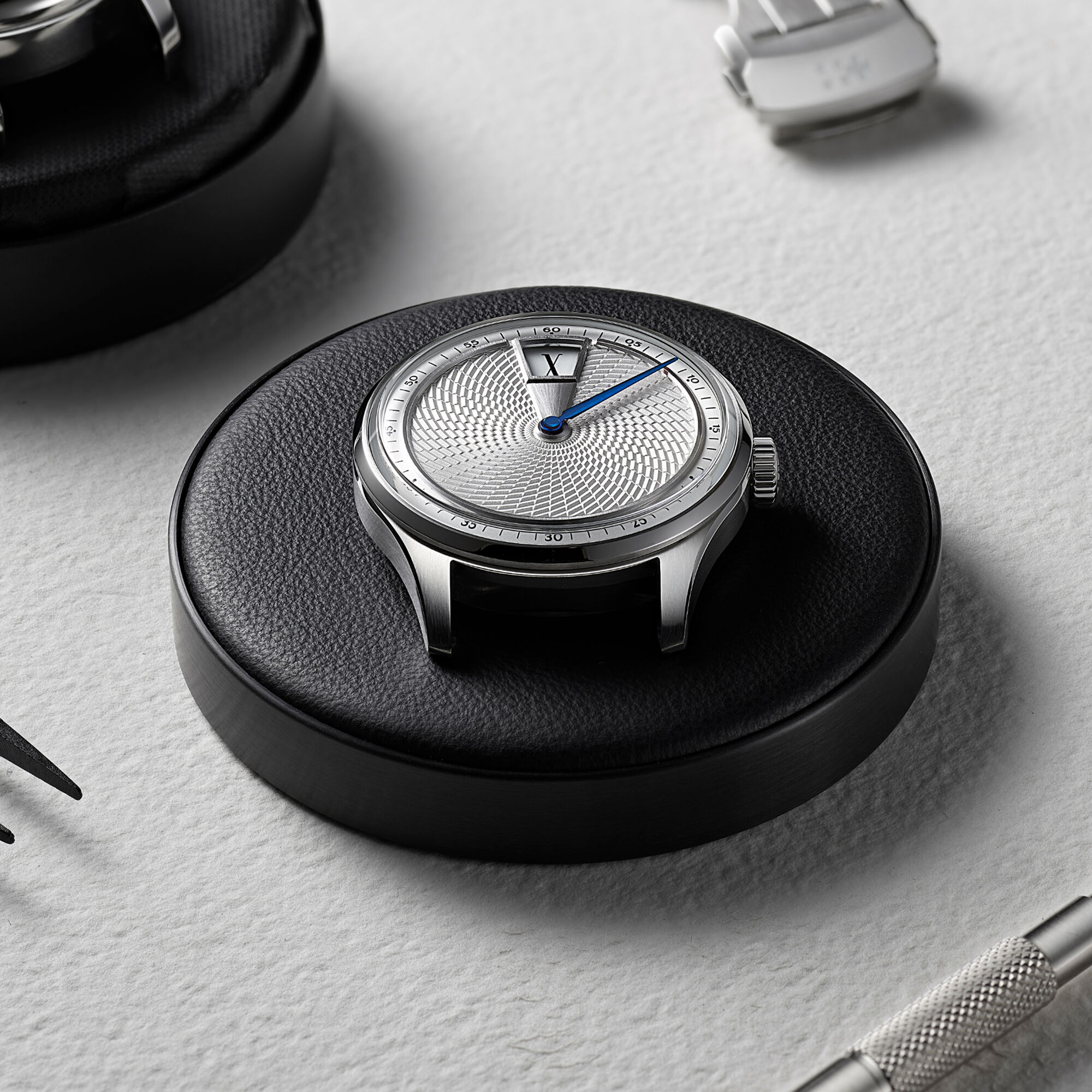 Christopher Ward C1 Jump Hour XV masa üstünde deri kayışla