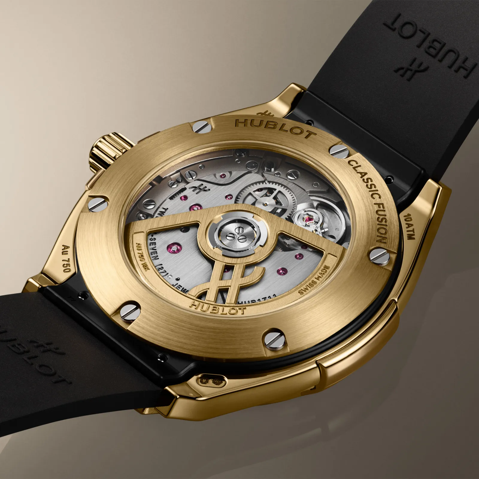 Hublot Classic Fusion Tributo sarı altın arka kapak ve HUB1711 Hublot Classic Fusion Tributo sarı altın safir arka kapaktan görünen HUB1711 mekanizması ve H biçimli sarı altın rotor