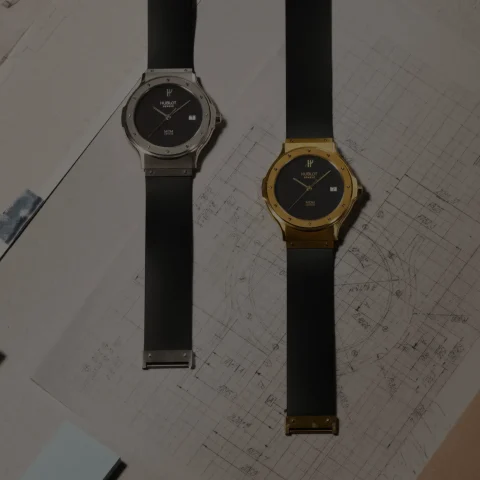Hublot Classic Fusion Tributo'nun 38 mm sarı altın ve beyaz altın sürümleri siyah kauçuk kayışla yan yana